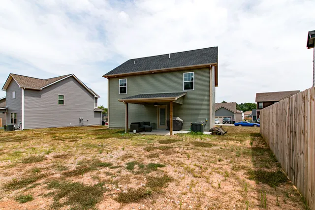 a view of a house with wooden fence and a bench