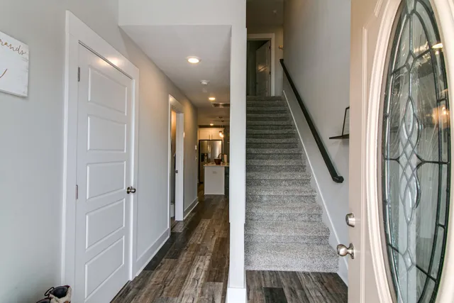 a view of a hallway with wooden floor and staircase
