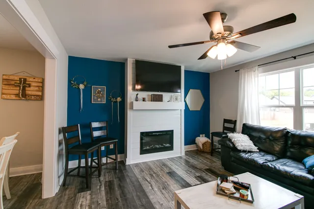 a living room with furniture a flat screen tv and a fireplace