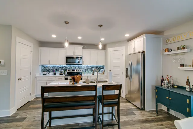 a kitchen with a refrigerator a dining table and chairs