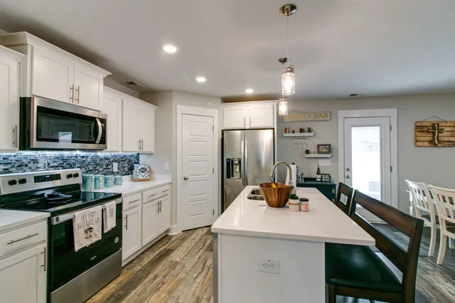 a kitchen with refrigerator a microwave a stove and cabinets