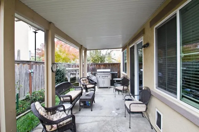 a living room with patio furniture and a potted plant