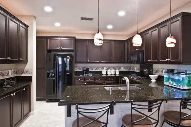 a kitchen with granite countertop a sink cabinets and stainless steel appliances