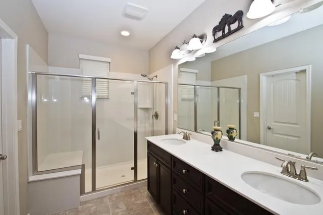 a bathroom with a double vanity sink mirror and shower