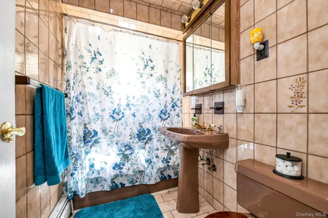 a bathroom with a sink and mirror with bathtub