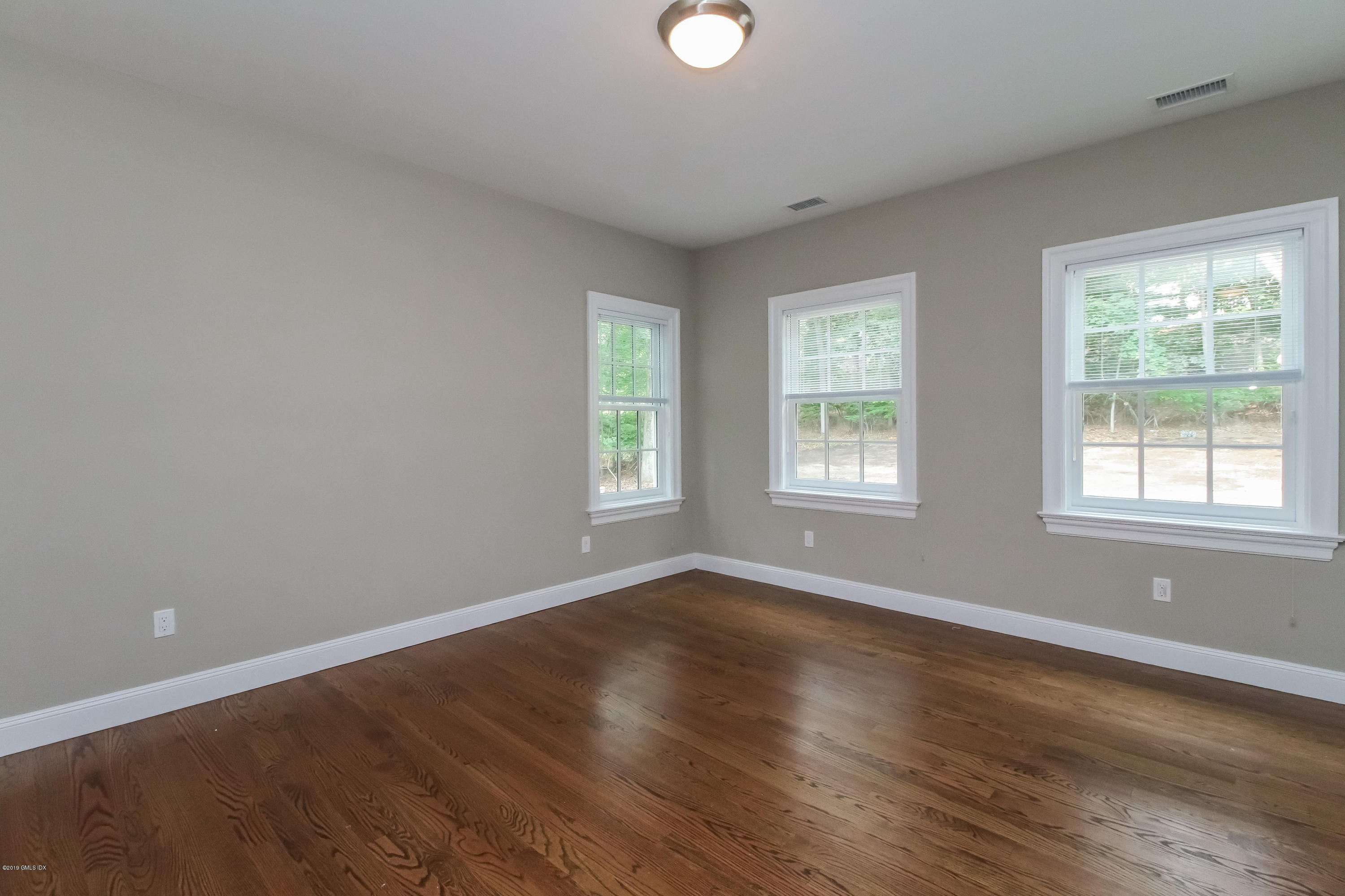 54 Dandy Drive Cos Cob, CT 06807 - Photo 22 of 35 a view of an empty room with wooden floor and a window