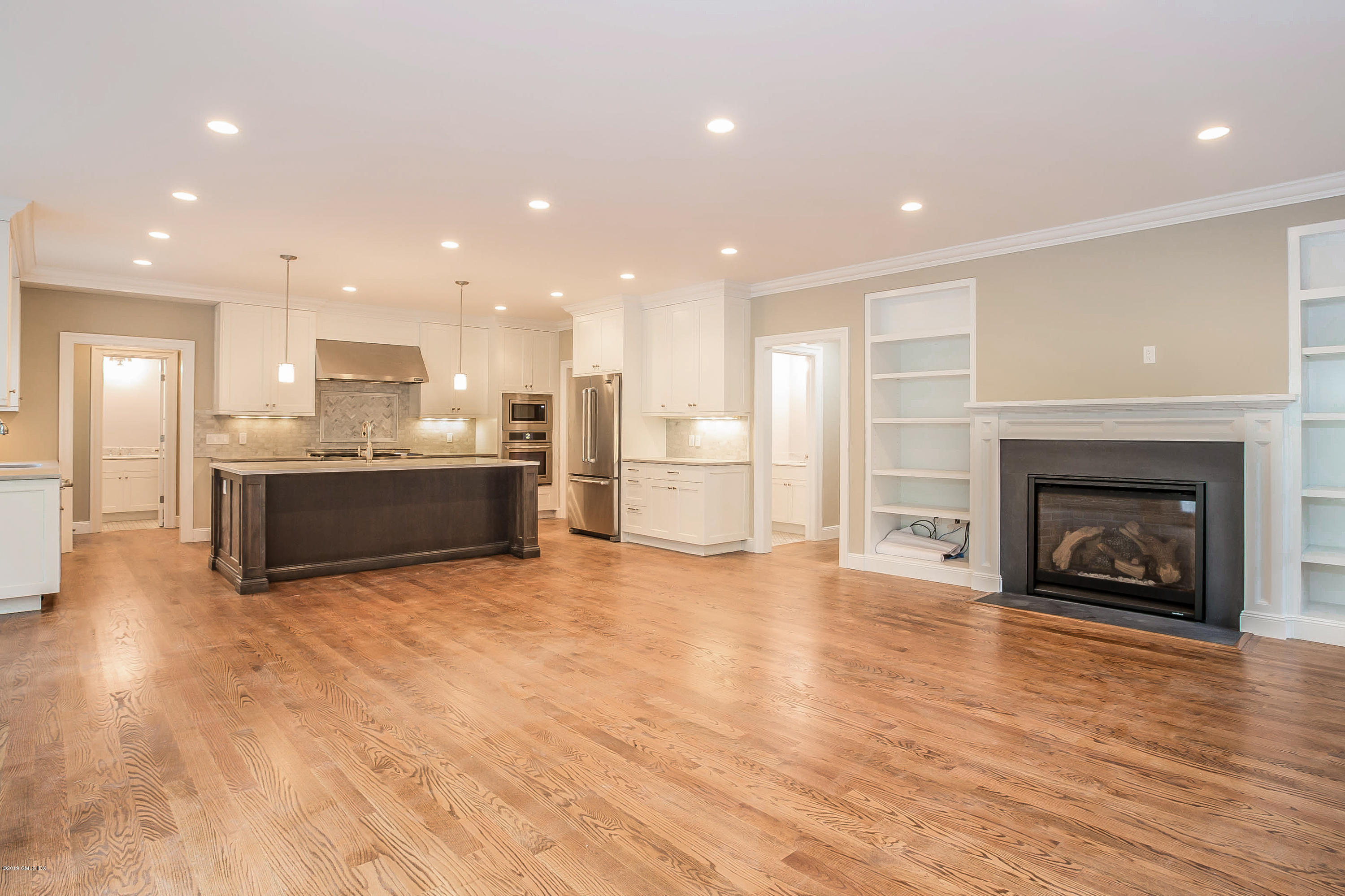 54 Dandy Drive Cos Cob, CT 06807 - Photo 3 of 35 a view of kitchen with kitchen island wooden floor and a fireplace