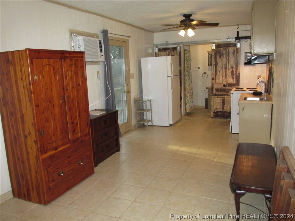a view of kitchen with refrigerator and wooden cabinets