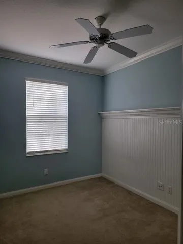 an empty room with a window and a fan