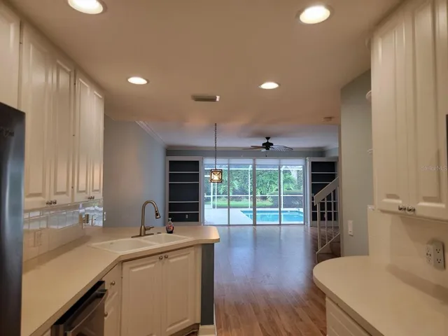 a kitchen with a sink and wooden floor