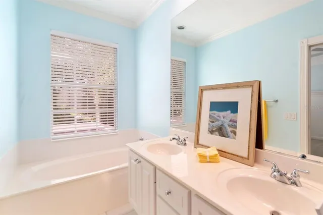 a bathroom with a tub a sink and mirror