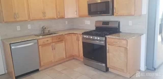 a kitchen with granite countertop white cabinets and stainless steel appliances