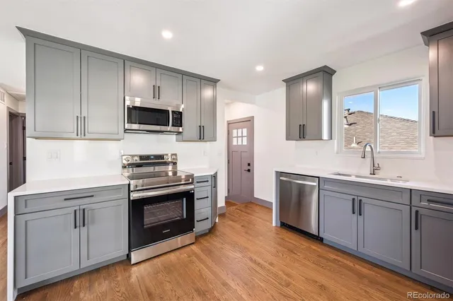 a kitchen with sink a microwave and cabinets