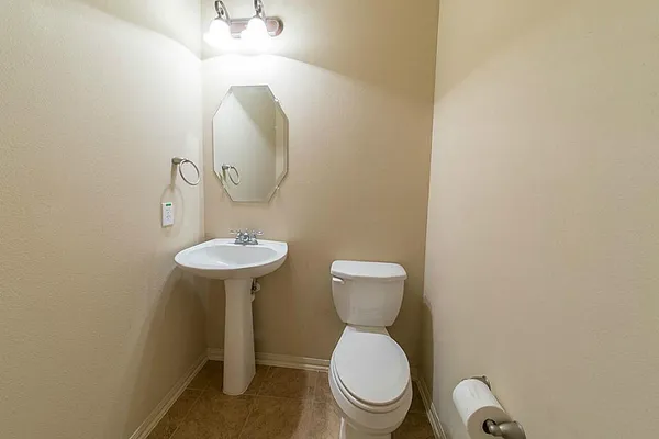 a bathroom with a toilet a sink and mirror