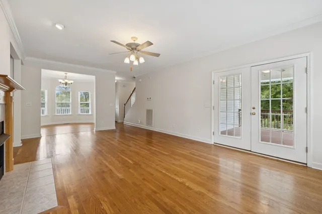 a dining room with wooden floor a chandelier a glass table and chairs
