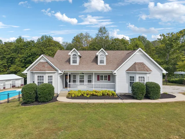 a front view of a house with a yard and potted plants