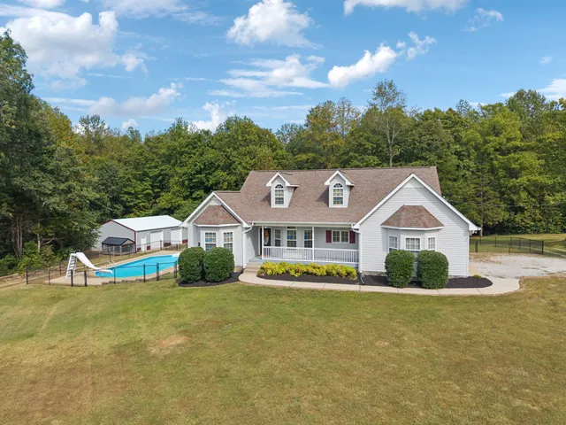 a front view of a house with a yard and trees