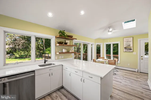 a large white kitchen with sink and cabinets