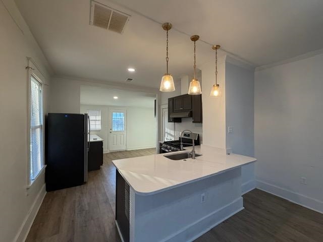 1073 Bruce Street Memphis, TN 38104 - Photo 3 of 12 a kitchen with a refrigerator a sink and a wooden floor