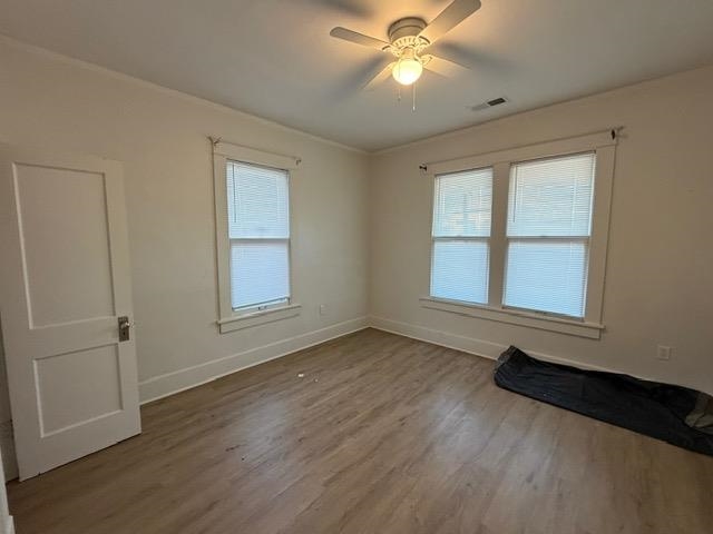 1073 Bruce Street Memphis, TN 38104 - Photo 9 of 12 an empty room with wooden floor fan and windows