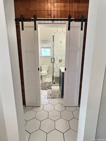 a bathroom with a glass door shower and a sink
