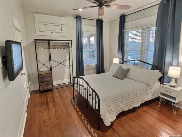 a bedroom with a bed a flat screen tv and a large window with the outer view