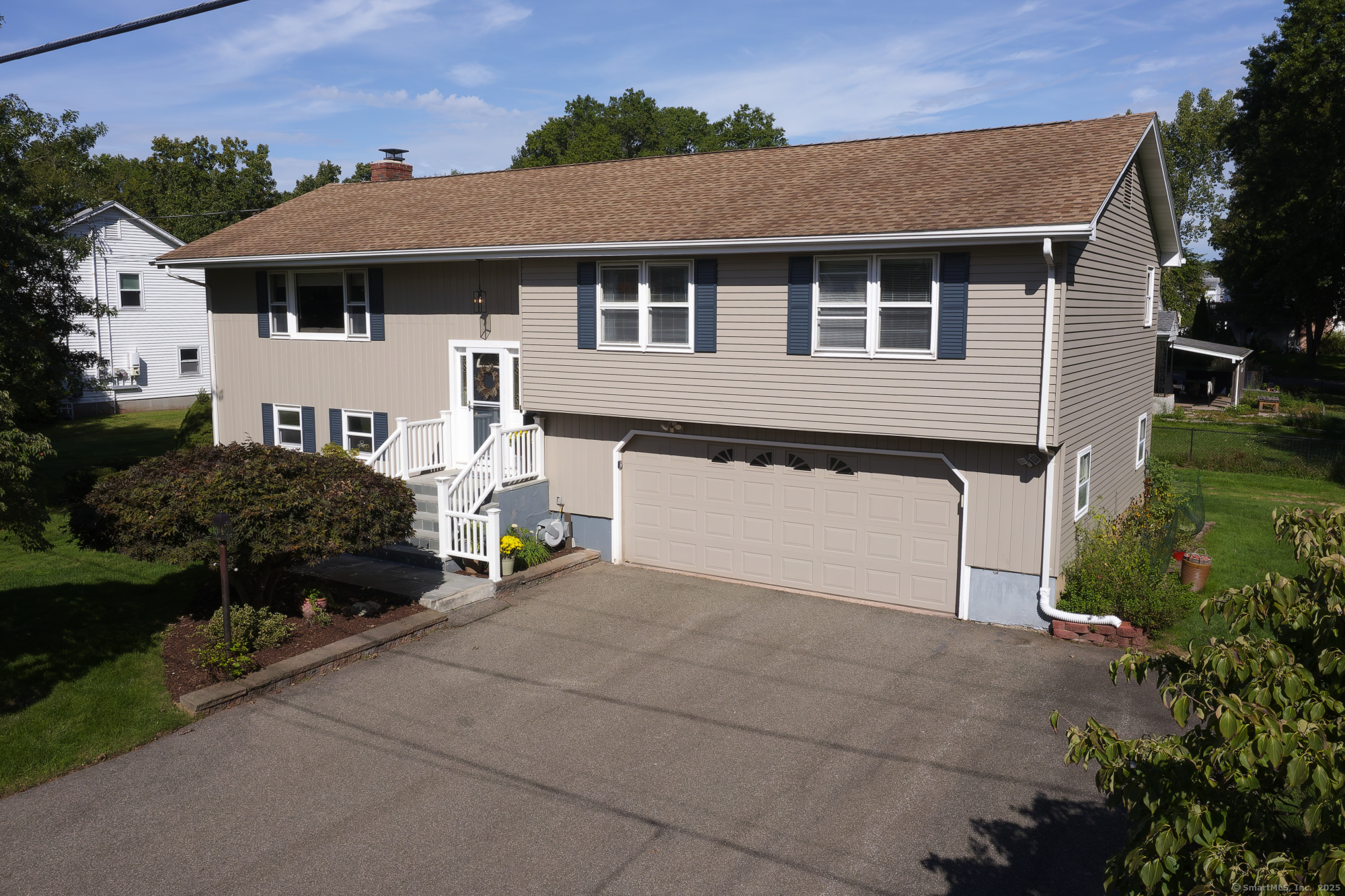 a front view of a house with a garden and parking space