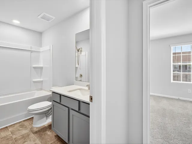 a bathroom with a sink toilet vanity and shower