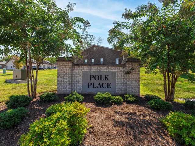 a view of a brick house with a yard potted plants