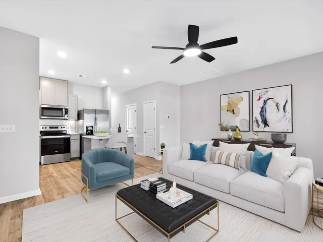 a living room with furniture and kitchen view