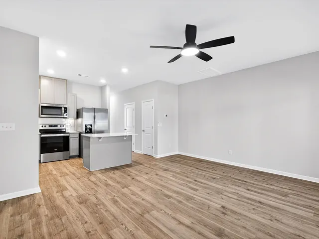 a kitchen with stainless steel appliances kitchen island granite countertop a refrigerator and a stove top oven