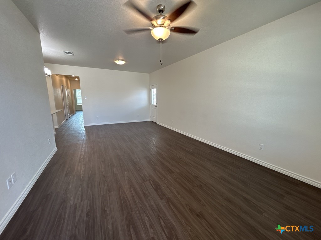 5110 Rose Gdn Loop Killeen, TX 76542 - Photo 2 of 19 an empty room with wooden floor and a ceiling fan