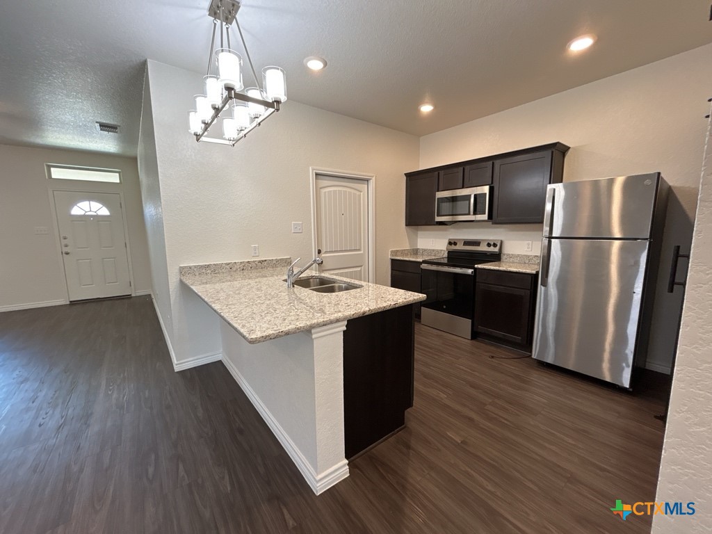 5110 Rose Gdn Loop Killeen, TX 76542 - Photo 6 of 19 a kitchen with stainless steel appliances granite countertop wooden floors a stove and a microwave