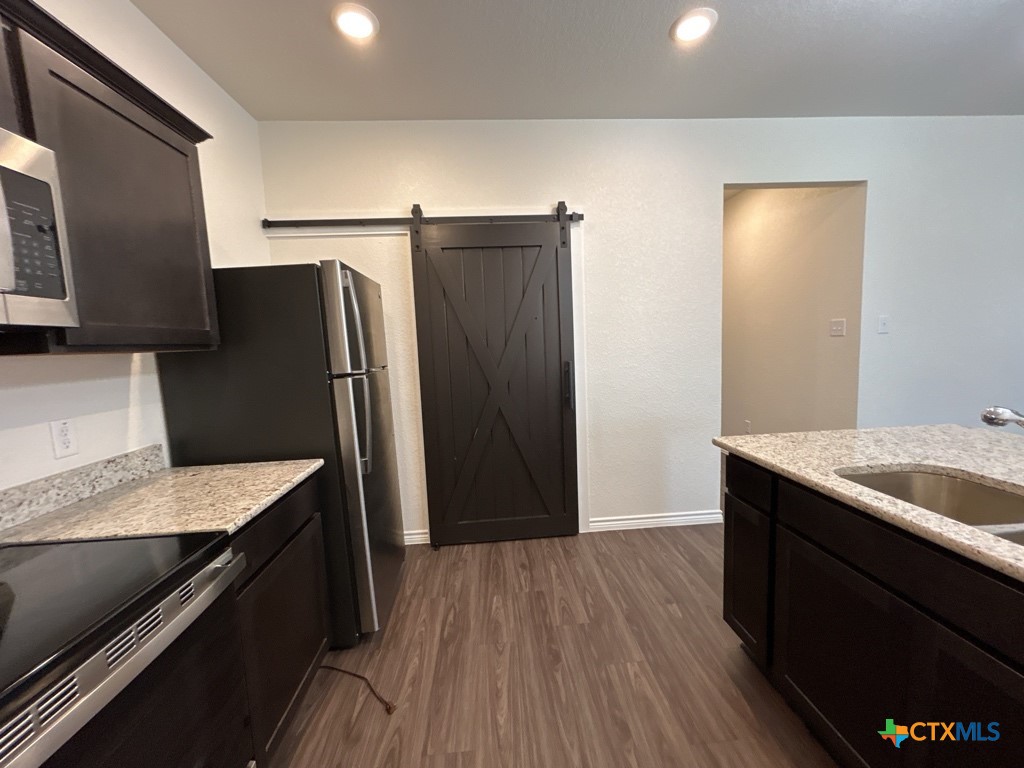 5110 Rose Gdn Loop Killeen, TX 76542 - Photo 10 of 19 a kitchen with granite countertop a refrigerator a sink and wooden cabinets