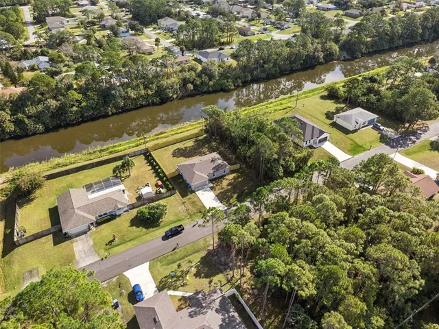 an aerial view of residential houses with outdoor space and trees