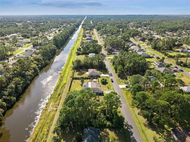 an aerial view of residential houses with outdoor space and trees