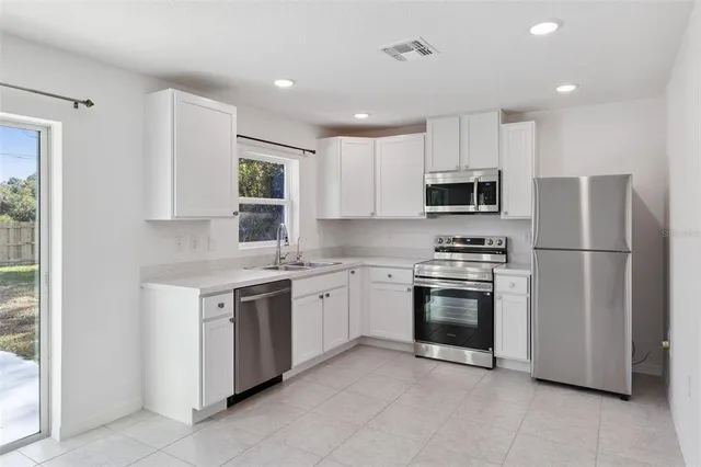 a kitchen with stainless steel appliances granite countertop a refrigerator stove a sink and a microwave