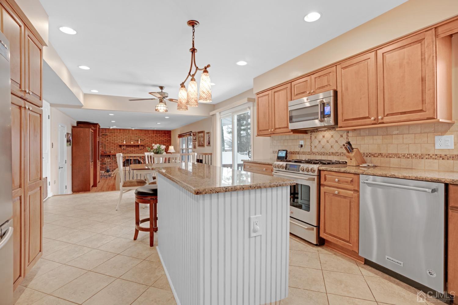 5 Diamond Drive Edison, NJ 08820 - Photo 12 of 35 a kitchen with stainless steel appliances granite countertop a stove top oven a sink dishwasher and a refrigerator with wooden floor