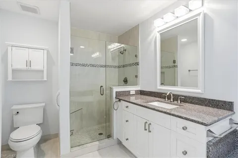 a bathroom with a granite countertop sink a mirror and a shower
