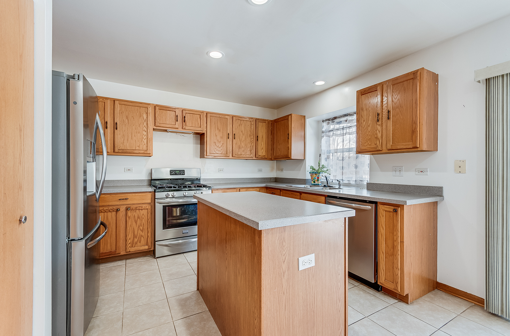 1544 Suncrest Lane Bolingbrook, IL 60490 - Photo 5 of 29 a kitchen with stainless steel appliances granite countertop a stove sink and cabinets