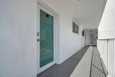 a view of a hallway with wooden floor and entryway