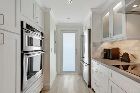 a kitchen with stainless steel appliances granite countertop a refrigerator and a stove top oven