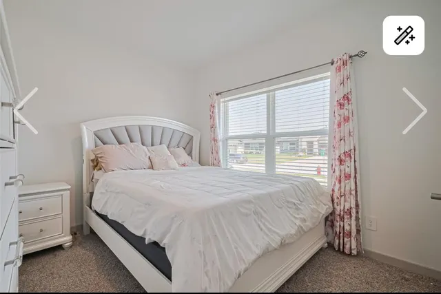 a large bed sitting in a bedroom next to a window
