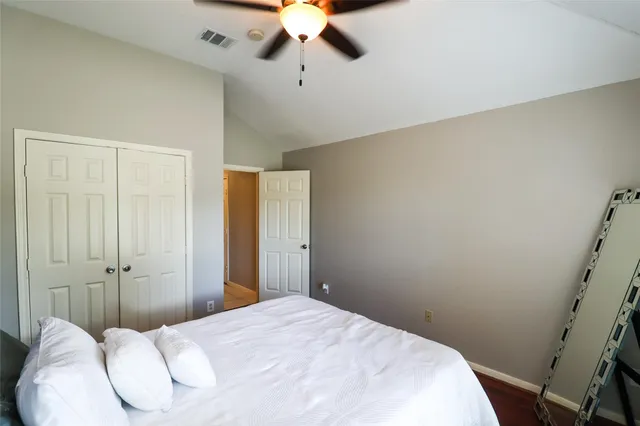 a bedroom with a bed and a ceiling fan