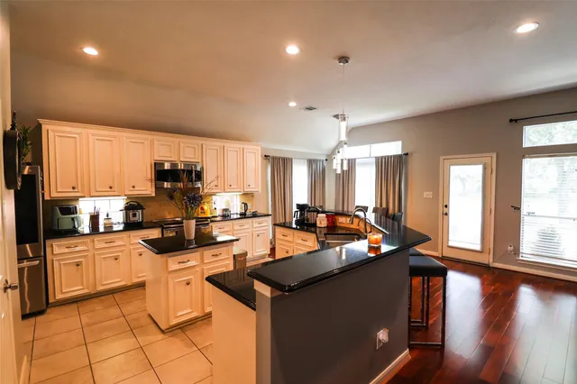 a kitchen with stainless steel appliances granite countertop a stove a sink a refrigerator and cabinets