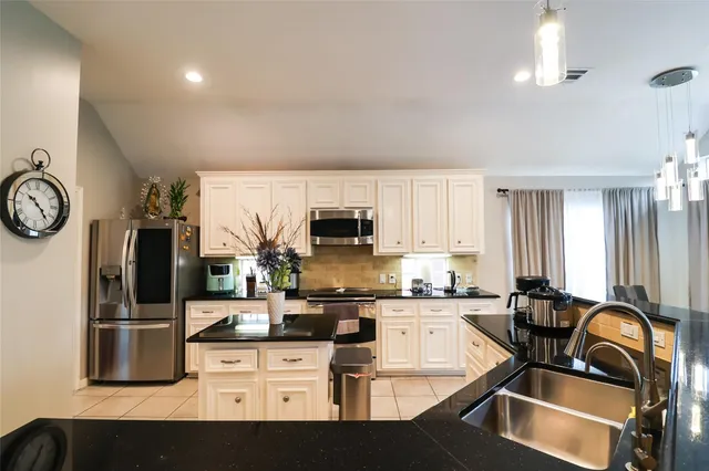 a kitchen with stainless steel appliances kitchen island granite countertop a sink and cabinets