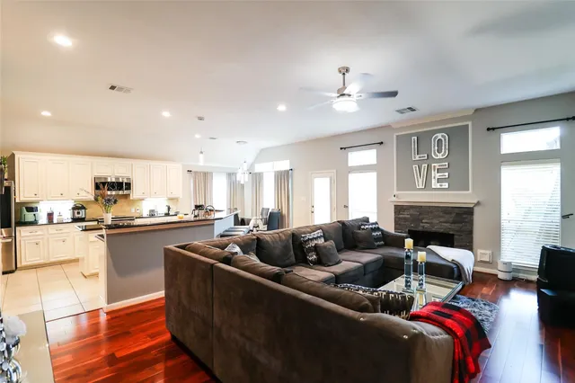 a living room with furniture kitchen view and a large window