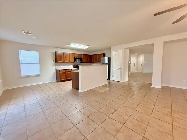 a view of a electric appliances in kitchen and empty room with windows