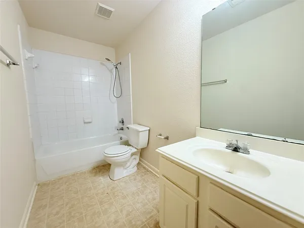 a bathroom with a granite countertop sink a toilet and shower