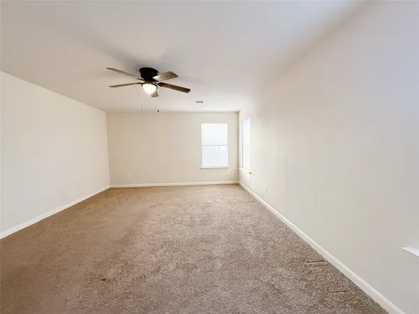 a view of a big room with windows and chandelier fan